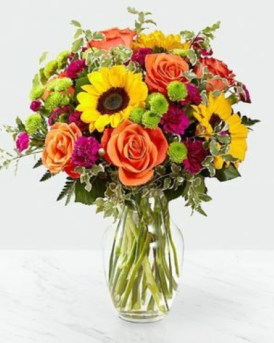 The Color Craze Bouquet blooms with a vibrant energy to create a special moment for your recipient! Our floral professionals weave together a blend of orange roses, sunflowers, violet mini carnations, green button poms, and lush greens to create an incredible gift. Presented in a clear glass vase, this truly colorful display of fresh flowers is ready to send your warmest birthday, thank you, or get well wishes straight to their door.
STANDARD bouquet is approx. 15H x 12W.
DELUXE bouquet is approx. 15H x 13W.
PREMIUM bouquet is approx. 16H x 14W.
